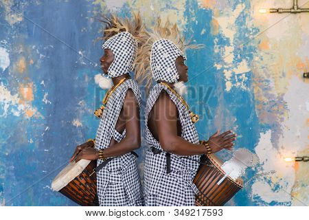 A Group Of People In Traditional African Costumes Playing Jembe Drums