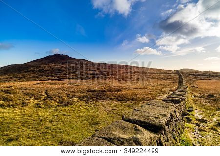 Mourn Wall On The Bank Of Slieve Donard Mountain With Blue Sky, White Clouds And Sunlight. Mourne Mo
