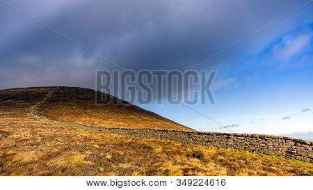 Mourn Wall On The Bank Of Slieve Donard Mountain With Blue Sky, White Clouds And Sunlight. Mourne Mo