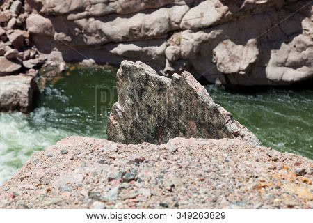 A Large Slab Of Granite Sticks Up From The Embankment Of The Bighorn River As It Winds Its Way Throu