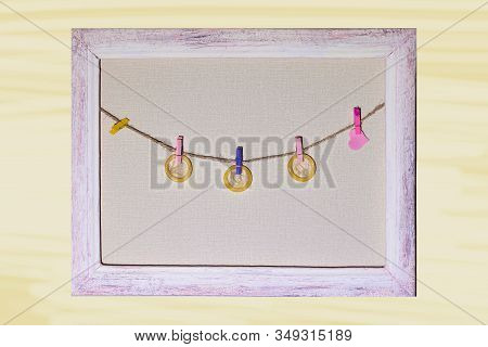 Condoms And A Heart On Clothespins Hanging On A Rope In A Frame