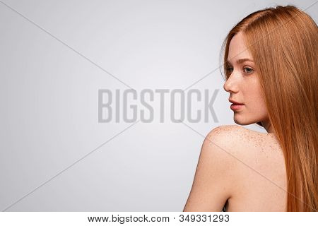 Back View Of Beautiful Young Woman With Ginger Hair And Freckled Skin Looking Away Over Shoulder Whi