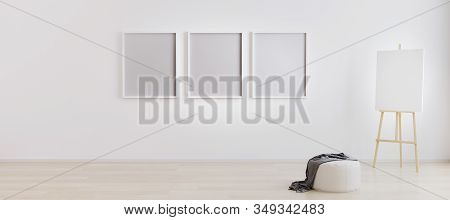 Easel With Canvas In Bright White Room With Three Blank Frames For Mockup. Artist Workspace. Empty B
