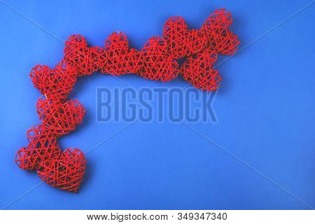 Beautiful Pattern Of The Red Wicker Hearts On The Cornflowerblue Background. St Valentines Concept W