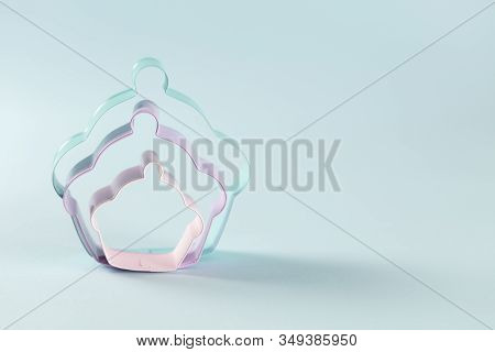 Three Metal Cookie Cuter Standing On Light Blue Background, With Copy Space