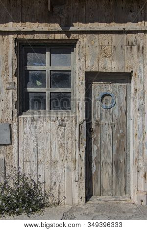Old Wooden Door With Porthole Window And A Window Of A Warehouse Or Barn, Wood Texture Or Background