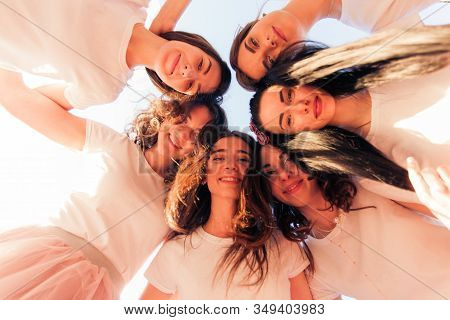 Group Of Girls Looking Down And Smiling