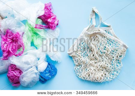 Many Disposable Plastic Bags Vs One Reusable Cotton Bag On A Blue Background. Zero Waste Shopping. S