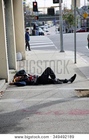 2-5-2020 China Town, Los Angeles CA. A person sleeps or enjoys the cold morning laying on the sidewalk of China Town in Los Angeles CA. Editorial use only.