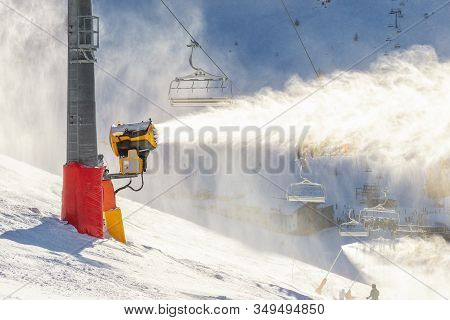 Operating Artificial Snow Cannon Near Piste Making Snowy Powder.ski Lift Ropeway On Hilghland Alpine