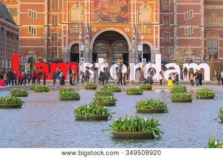 Amsterdam, Netherlands - March 31, 2016: Water And Colorful Tulip Flowers, Rijksmuseum And People In