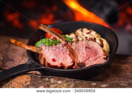 Two Juicy Pieces Of Rack Of Lamb In A Pan On A Background Of Fire From The Oven
