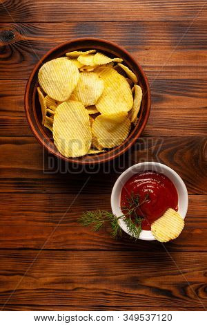 Wavy, Potato Chips In A Plate With Ketchup On A Wooden Table. Top View Of Snacks. Stock Photo Potato