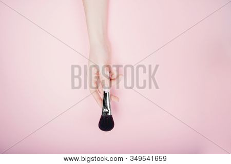 Girl Artist Hand With Brushes Makeup On Pink Color Background. Top View Flat Lay