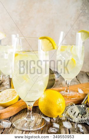 Trendy Summer Cold Drink. St Germain French Spritz Cocktail With Lemon Slices, Old Rustic Wooden Bac