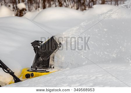 Man Is Brushing White Snow With The Yellow Electric Snow Thrower In A Winter Garden