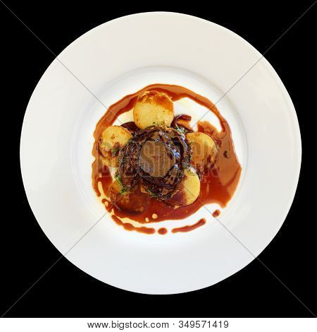 Fillet mignon steak with potatoes shot from above, isolated on black background