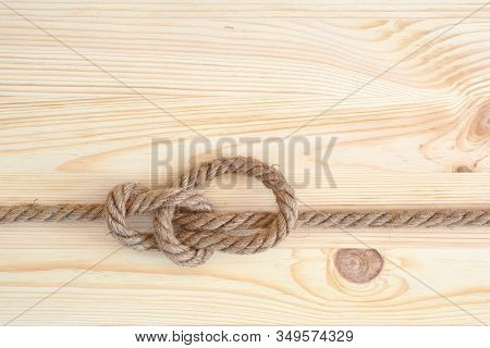 Marine Knot Used In Yachting, Bowline Knot. Nautical Knot On Wooden Background.