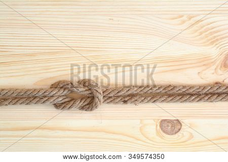 Marine Knot Used In Yachting, Square Knot. Nautical Knot On Wooden Background.