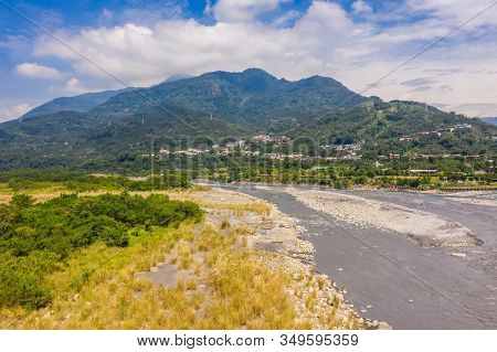 landscape of golden miscanthus with mountain and river under sky
