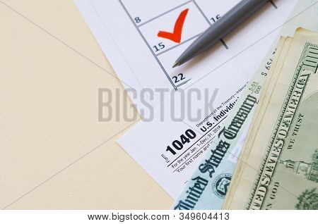 1040 Individual Income Tax Return Form With Refund Check And Hundred Dollar Bills On Calendar With M