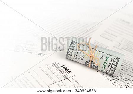 1065 U.s. Return Of Parentship Income Form With Roll Of American Dollar Banknotes