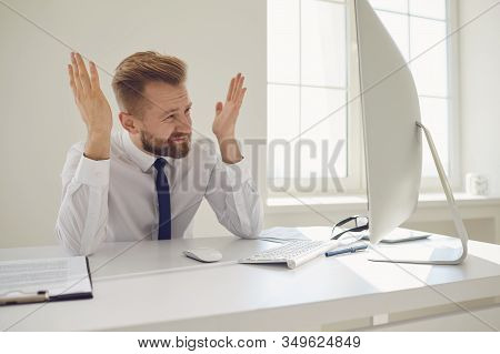 Upset Tired Businessman Raised His Hands Up Looking At A Computer At A Desk In The Office.