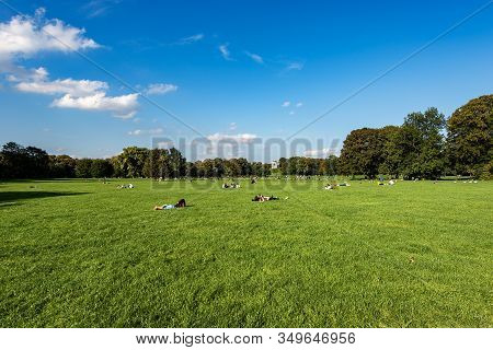 The Englischer Garten (english Garden) In Downtown Of Munich, Bavaria, Germany. Tourists And Locals 