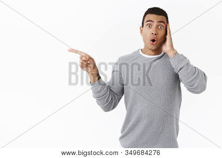 Oh My Have You Seen It. Amazed And Curious, Astonished Young Hispanic Guy Pointing Left And Folding 