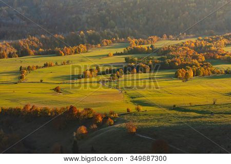 Beautiful Aerial View Of An Autumn Landscape Of A Green Valley With Colored Trees In The Golden Hour