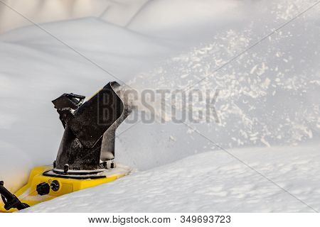 Man Is Brushing White Snow With The Yellow Electric Snow Thrower In A Winter Garden