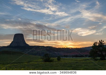 Devils Tower National Monument At Sunset With A Soft Glowing Landscape And A Camping Area Full Of Pe