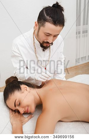 Reflexologist Doing Acupuncture To Treat A Woman Patient. Acupuncture Is Part Of Traditional Chinese