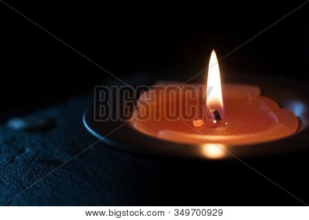 Candle Light In Tray On A Black Table. Close Up.