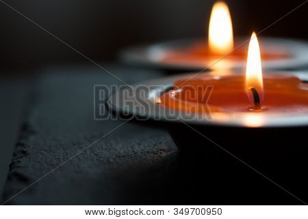 Candle Light In Tray On A Black Table. Close Image.