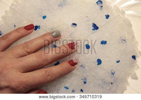 White And Blue Stones. A Woman\'s Hand On Silicone Crystals.