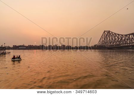 Kolkata, India - March 11, 2019: Indian Children Sail On Homemade Raft On Hooghly Or Ganga In Sunset