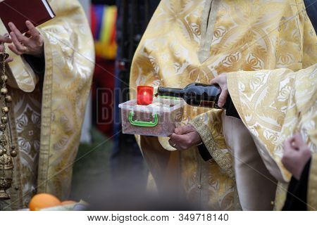 Shallow Depth Of Field (selective Focus) Image With An Orthodox Priest Pouring Wine On A Funeral Cak