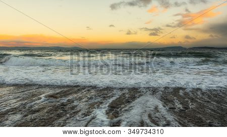 Beautiful Sunset Along A Rocky Beach With Big Waves