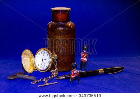 A Tableau Of Antiques On A Blue Felt Background, Including A Gold Pocket Watch And Chain, Fountain P