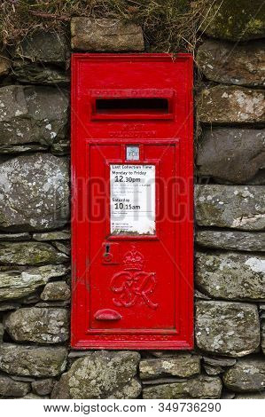 Buttermere, England - March 31:  A Traditional Red English Letterbox Mounted In A Dry Stone Wall In 