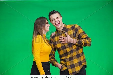 Portrait Of Girl Whispering Into Mans Ear, Telling Him Something Really Funny Because He Is Smiling 