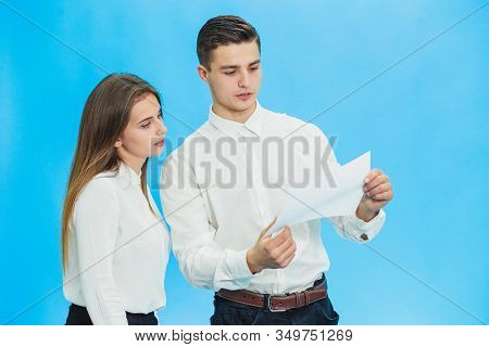 Serious Director And His Assistant Checking Documentation And Looking For Mistakes Over Blue Backgro