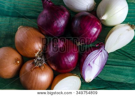 Onions Of Three Colors On A Green Background Top View