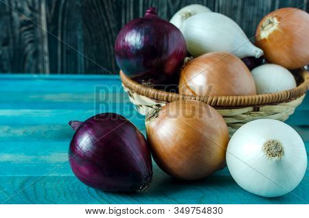 Red, Beige And White Onions In The Foreground Is A Basket Of Bulbs In The Background
