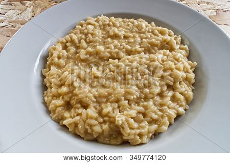 Rice With Eggs And Parmigiano Reggiano On Wooden Table. Italian Risotto With Eggs And Cheese