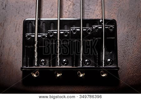 Bass Electric Guitar With Four Strings Closeup. Detail Of Popular Rock Musical Instrument. Close Vie