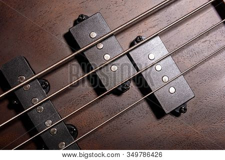 Bass Electric Guitar With Four Strings Closeup. Detail Of Popular Rock Musical Instrument. Close Vie