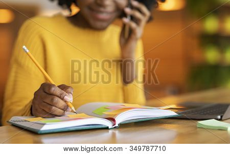 Job Hunting. Cropped Of Afro Girl Talking By Phone With Hr Representetive , Taking Notes, Cafe Inter