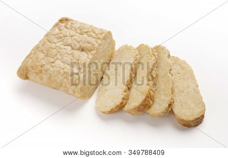 Brick Of Asian Tempeh Cut Into Slices, Isolated On White Background